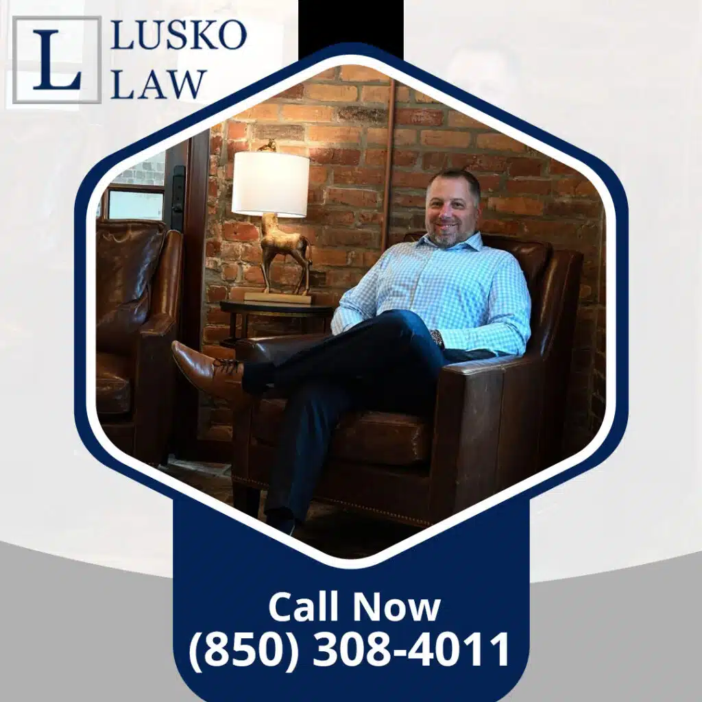 An attorney sitting in a leather armchair in front of an exposed brick wall inside the Lusko Law office.