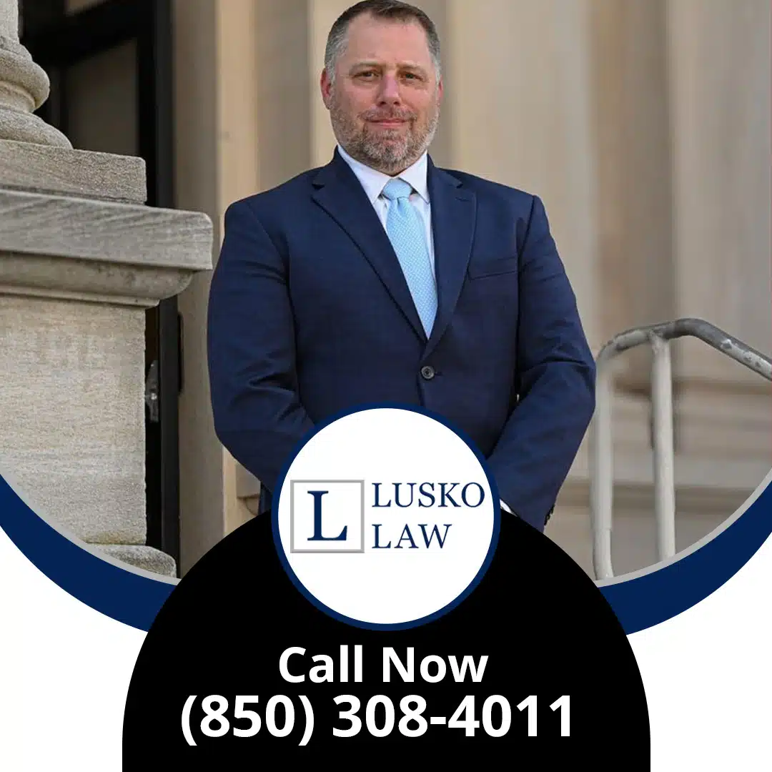 Professional portrait of an attorney in a suit standing outside a courthouse entrance, branded for Lusko Law.